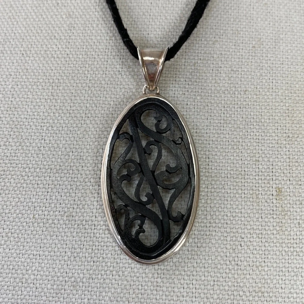Carved wood pendant 925 on black cord